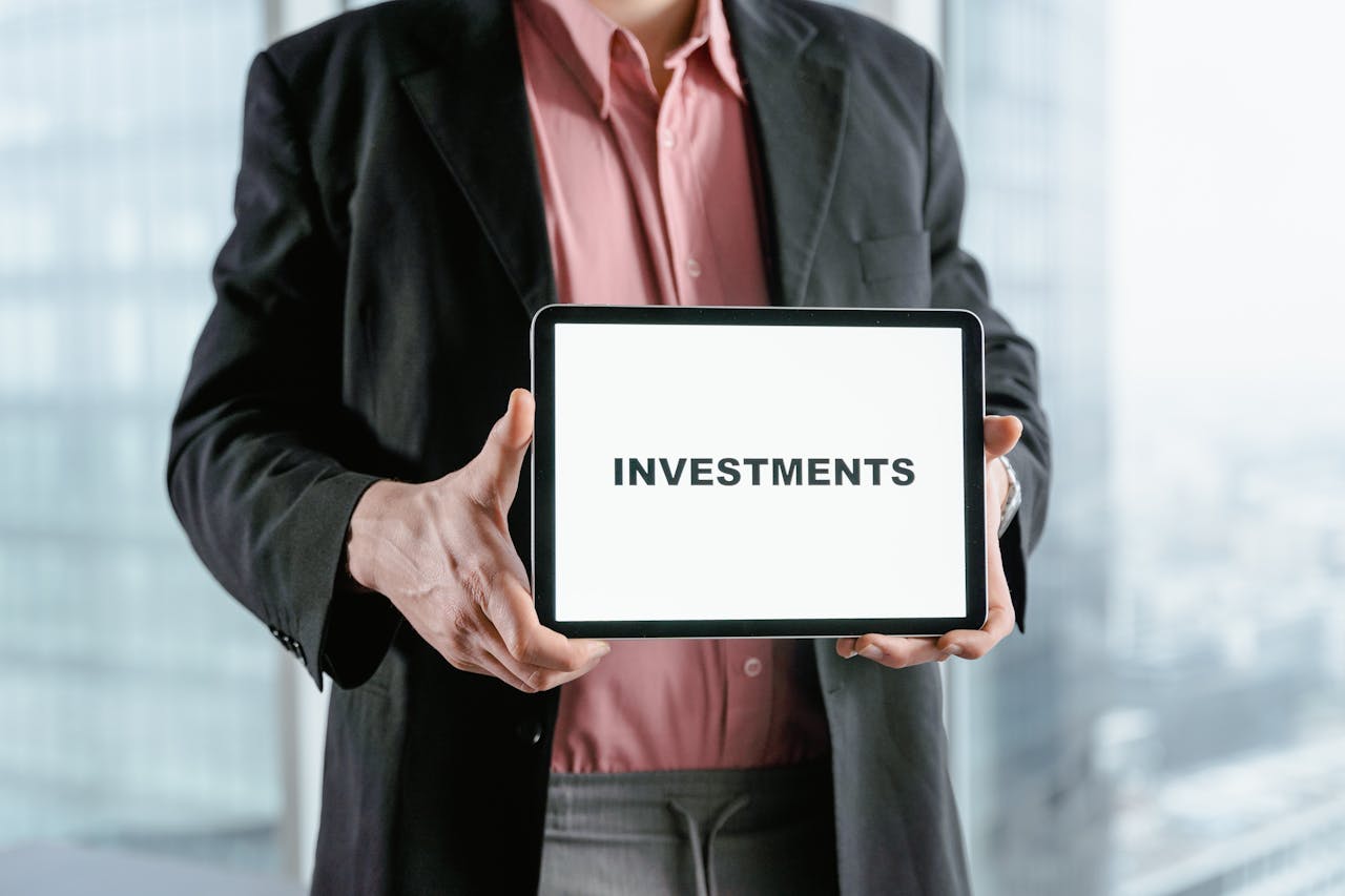 Services Professional holding a tablet with 'INVESTMENTS' text, ideal for finance and business themes.